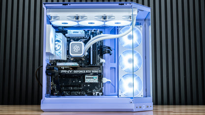 Custom-built gaming PC in a translucent lavender case with liquid CPU cooler, MSI motherboard, PNY GeForce RTX 5060 Ti graphics card, and white RGB fans, set against a dark wood slatted background