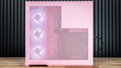 Pink computer case with mesh front panel and three visible fans, standing on a wooden floor against a dark slatted wall